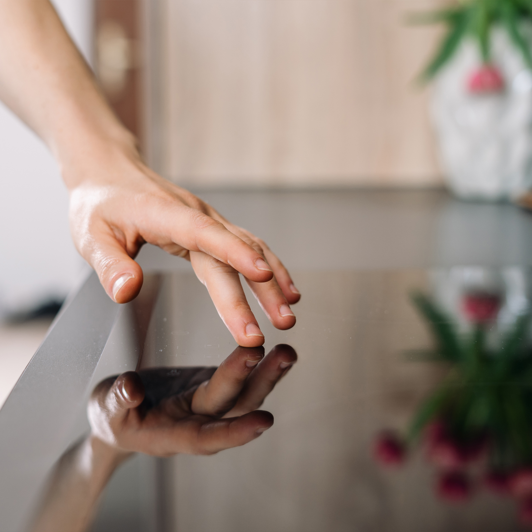 Eine Person fährt mit ihrem Finger über eine schwarze Arbeitsplatte einer Küche