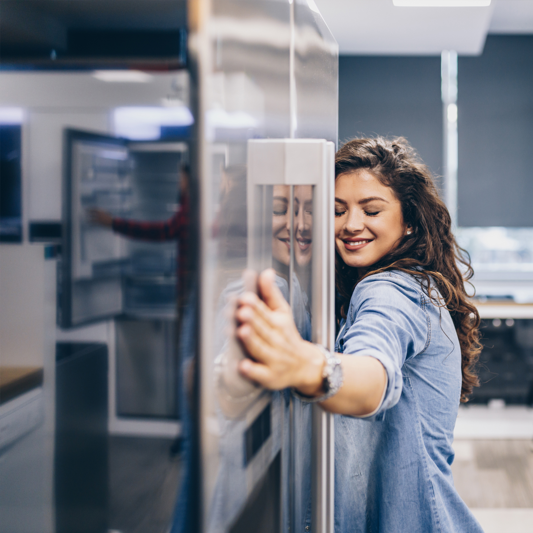 Junge Frau umarmt einen Kühlschrank